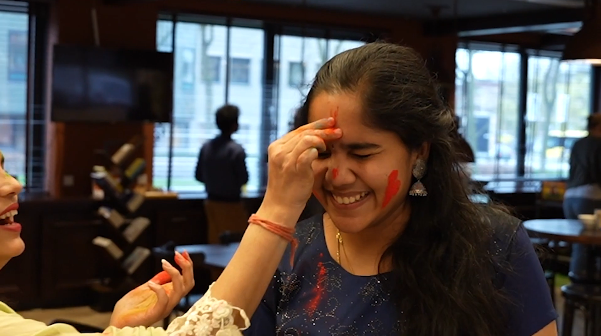 Bright woman at Keylane Careers celebrating a fun, joyful moment with colorful face paint, showcasing a vibrant workplace environment and positive team culture that supports employee happiness and engagement.