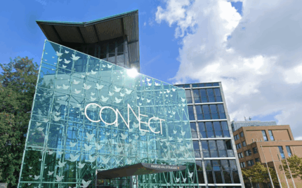 Modern glass building with "Connect" sign, showcasing innovative corporate architecture at Keylane Careers campus, symbolizing connectivity and forward-thinking in the insurance technology industry.