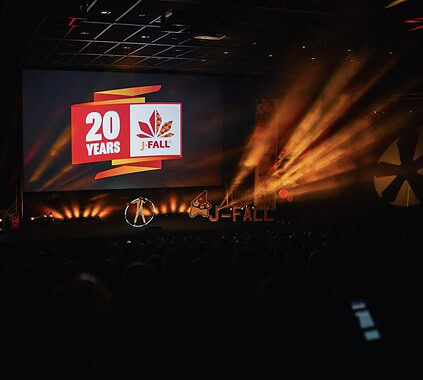 1. Celebrating 20 years of Keylane and J-Fall with a dynamic event featuring stage lighting, a large screen, and company branding.